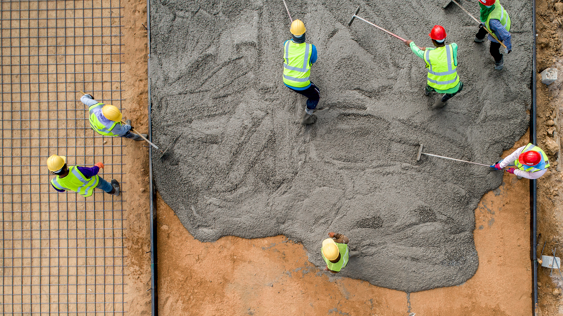 A construction worker pouring a wet concret at road construction